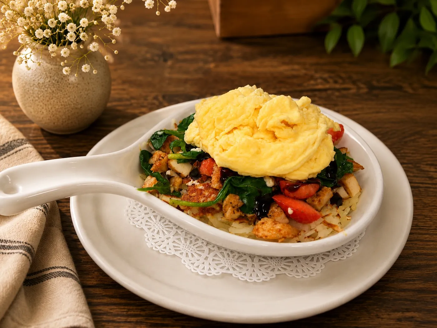 Skillet of vegetables and meat topped with fluffy scrambled eggs